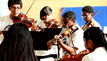 Students perform with string instruments in the Watts Willoughby Center program
