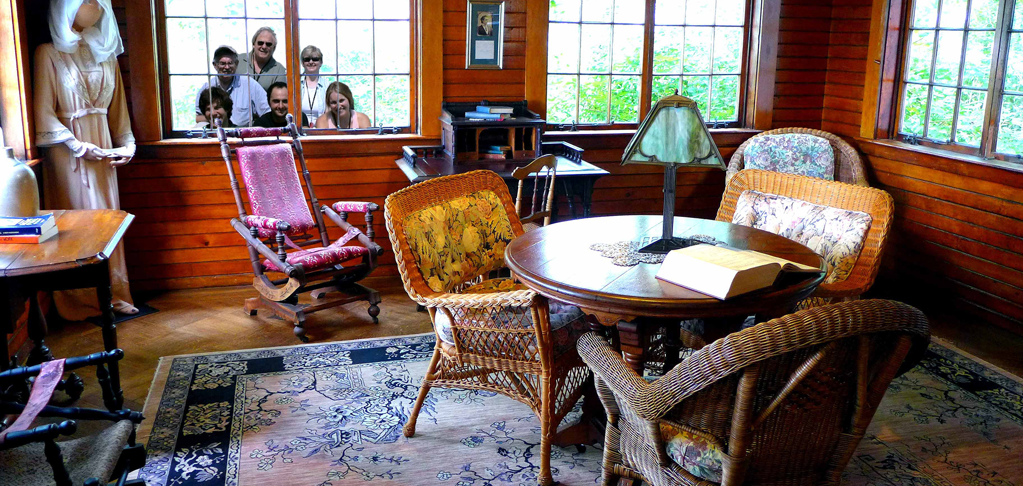 Some of the 2008 O'Neill Center Theater Critics peer into the sun room at Monte Cristo Cottage, set up to reflect the stage directions for Eugene O'Neill's final play Long Day's Journey into Night. (David Lyon for The Boston Globe)